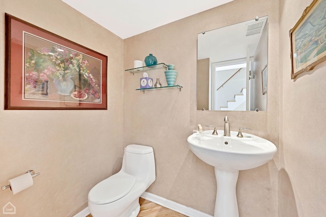 bathroom with sink, toilet, and hardwood / wood-style floors