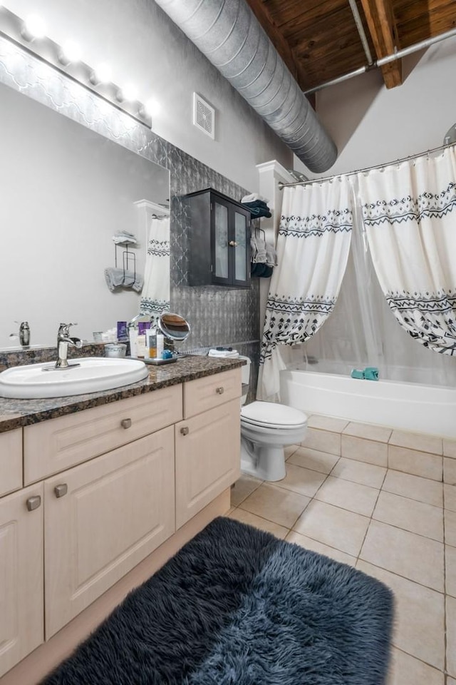 full bathroom with vanity, shower / bathtub combination with curtain, tile patterned floors, and toilet