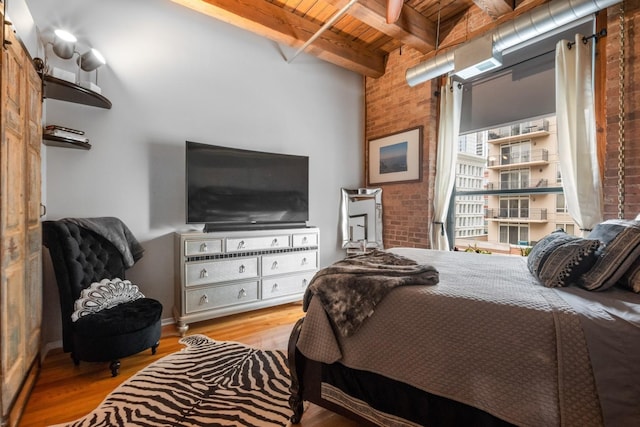 bedroom with wood ceiling, brick wall, beam ceiling, and light wood-type flooring