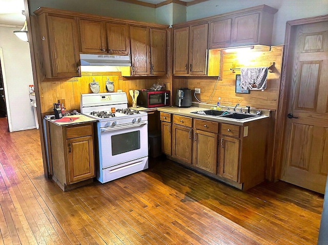 kitchen featuring crown molding, sink, dark hardwood / wood-style floors, and white gas range oven