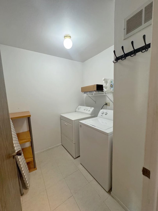 washroom featuring light tile patterned floors and washing machine and clothes dryer