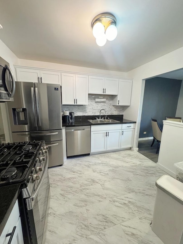 kitchen featuring tasteful backsplash, white cabinetry, appliances with stainless steel finishes, and sink