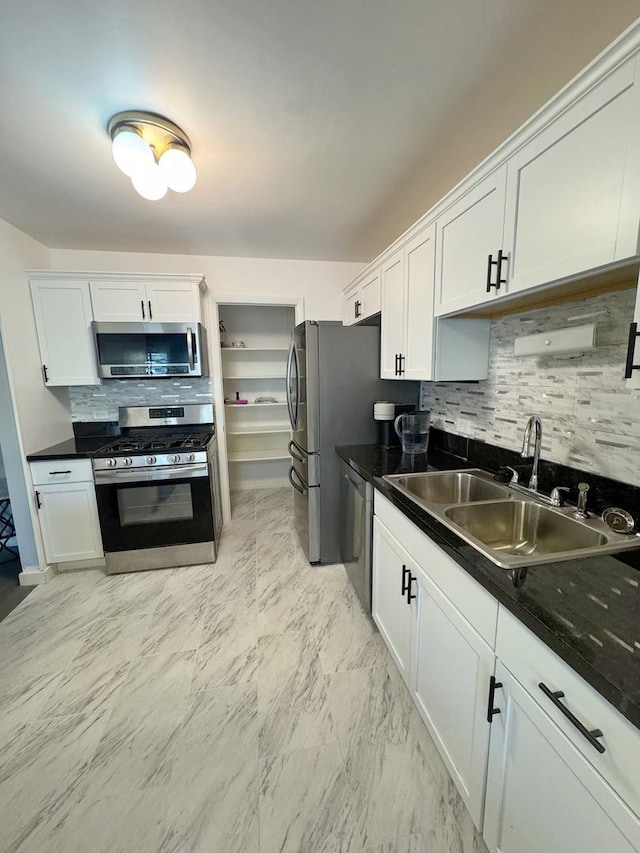 kitchen featuring white cabinetry, sink, decorative backsplash, and appliances with stainless steel finishes