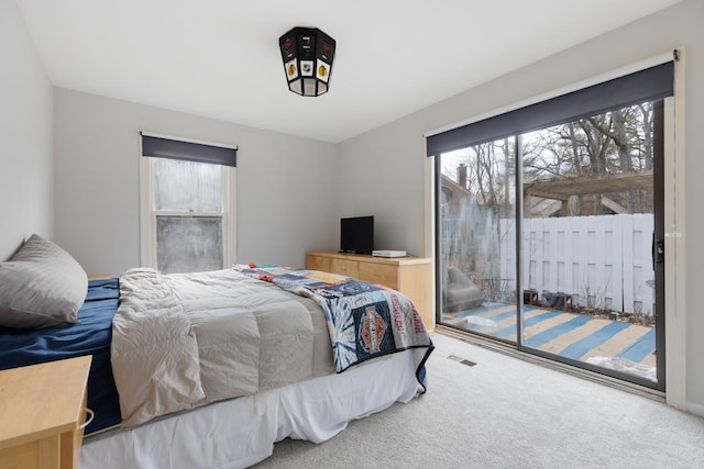 carpeted bedroom with access to exterior and visible vents