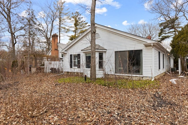 rear view of property featuring fence and a chimney