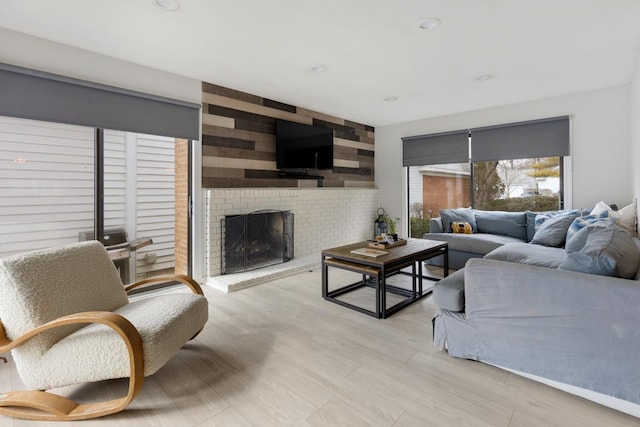 living room with recessed lighting, a fireplace, and light wood-style flooring