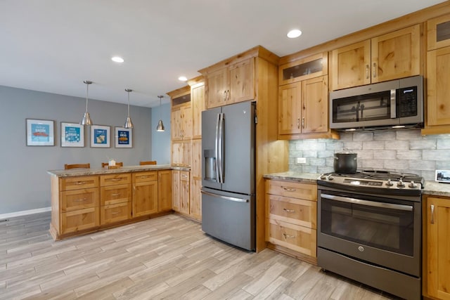 kitchen featuring a peninsula, light wood-style flooring, stainless steel appliances, and backsplash