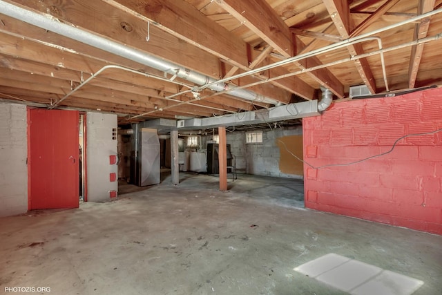 basement with heating unit and washer / dryer