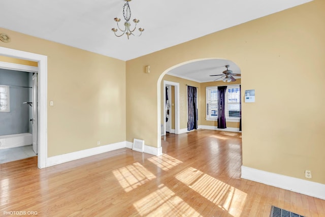 spare room with wood-type flooring and ceiling fan with notable chandelier