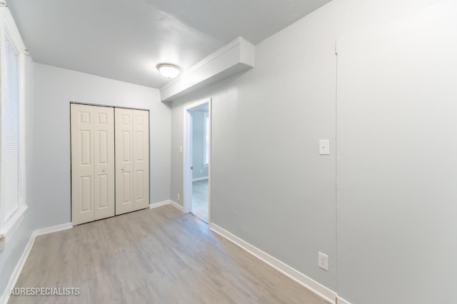 unfurnished bedroom with light hardwood / wood-style floors and a closet