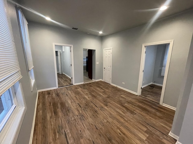 unfurnished bedroom featuring connected bathroom and dark hardwood / wood-style flooring