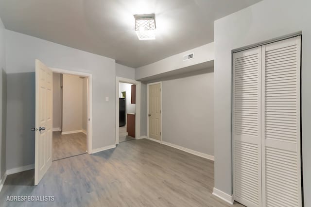 unfurnished bedroom with a closet and light wood-type flooring