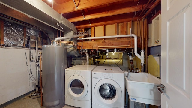 clothes washing area with sink, washer and clothes dryer, and water heater