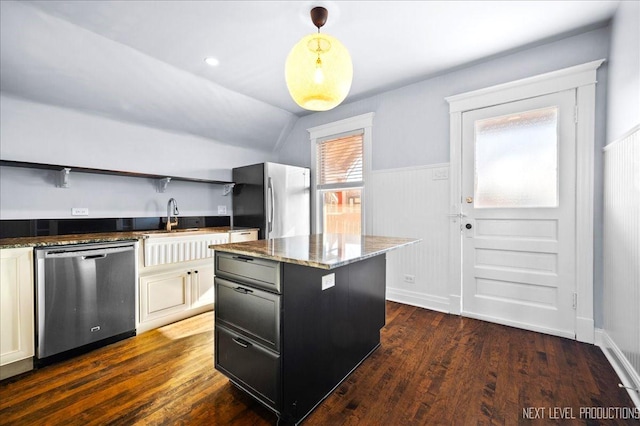 kitchen featuring a center island, hanging light fixtures, appliances with stainless steel finishes, dark hardwood / wood-style floors, and dark stone counters