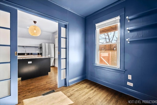 entryway with hardwood / wood-style floors and crown molding