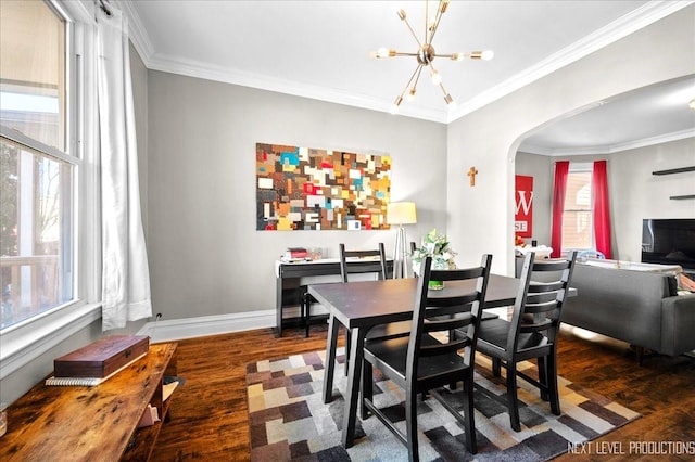 dining space featuring a notable chandelier, ornamental molding, and dark hardwood / wood-style floors