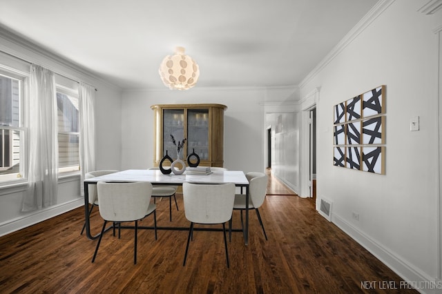 dining area featuring ornamental molding and dark hardwood / wood-style flooring