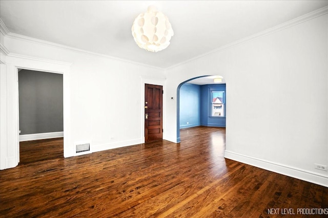 empty room featuring crown molding and dark hardwood / wood-style floors