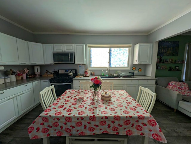 kitchen featuring sink, ornamental molding, stainless steel appliances, and white cabinets