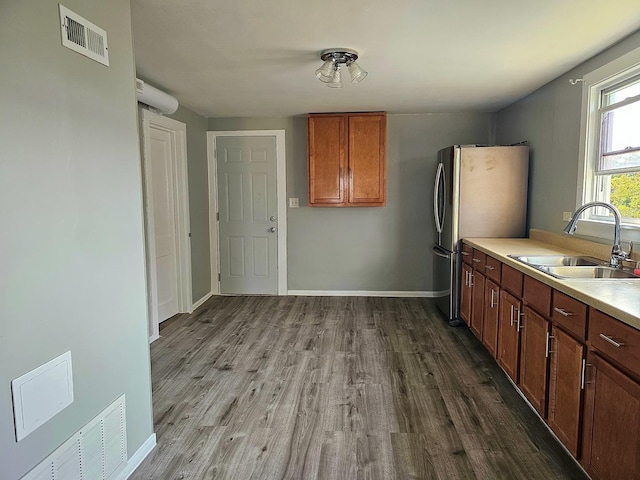 kitchen featuring sink, hardwood / wood-style floors, and stainless steel fridge