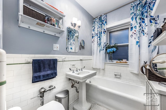 bathroom featuring toilet and tile walls