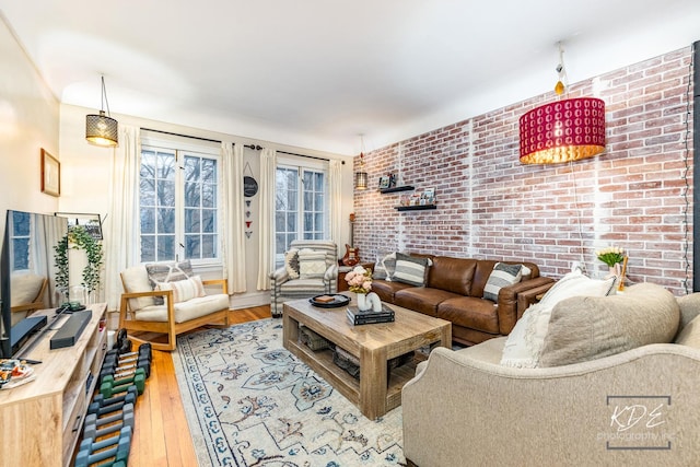 living room with brick wall and hardwood / wood-style floors