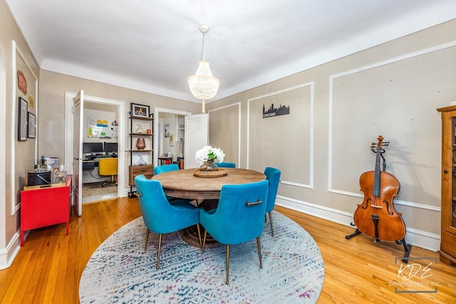 dining room with an inviting chandelier and light hardwood / wood-style flooring