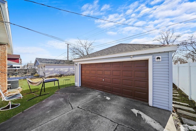 garage with central AC unit and a lawn