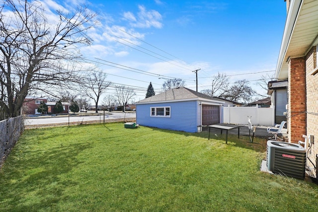 view of yard featuring central AC unit, a garage, and an outdoor structure