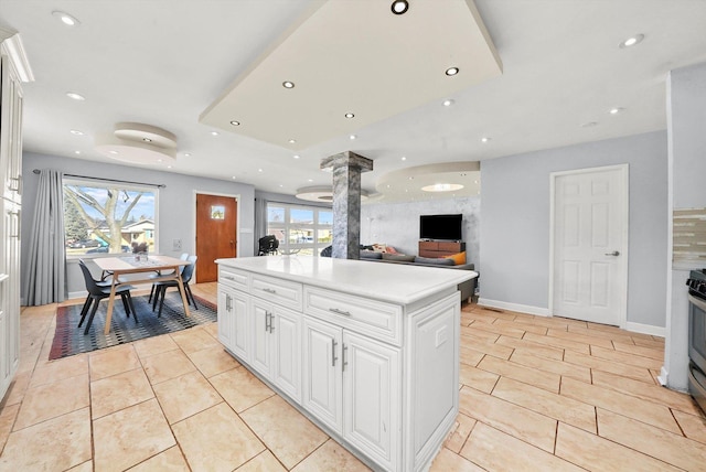 kitchen featuring white cabinetry, gas stove, a center island, and light tile patterned flooring