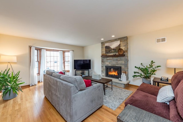 living room with a fireplace and light wood-type flooring