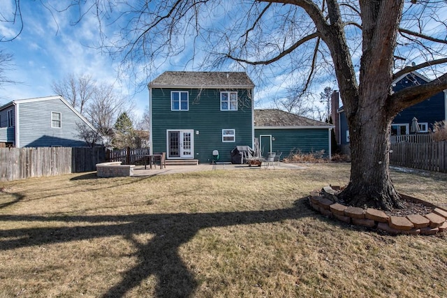 rear view of house featuring a fire pit, a lawn, and a patio