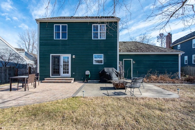 rear view of house featuring a patio, a yard, and french doors