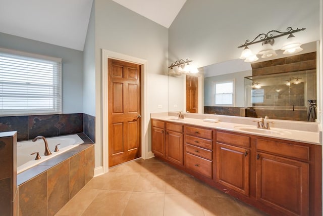 bathroom with tile patterned floors, lofted ceiling, independent shower and bath, and vanity