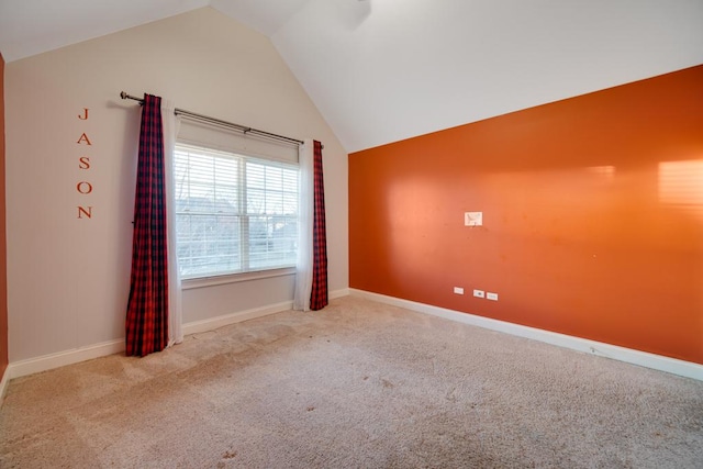 unfurnished room with lofted ceiling and light carpet