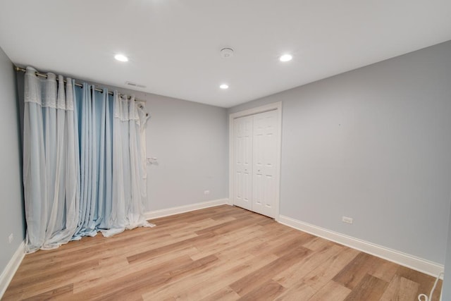 unfurnished bedroom featuring light wood-type flooring and a closet