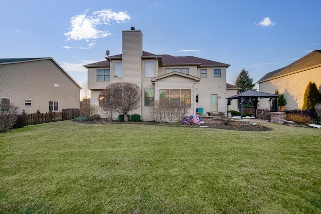 back of property with a gazebo and a lawn