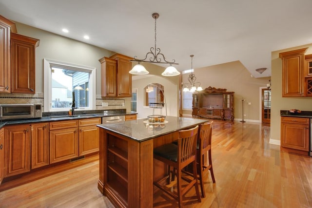 kitchen with pendant lighting, a breakfast bar area, a center island, and light hardwood / wood-style flooring