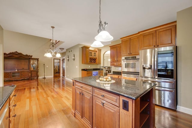 kitchen featuring pendant lighting, light hardwood / wood-style floors, a center island, and appliances with stainless steel finishes