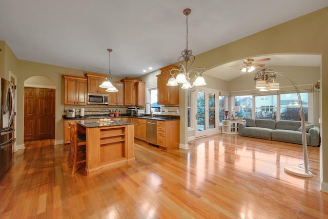 kitchen with light hardwood / wood-style flooring, a center island, a healthy amount of sunlight, and appliances with stainless steel finishes