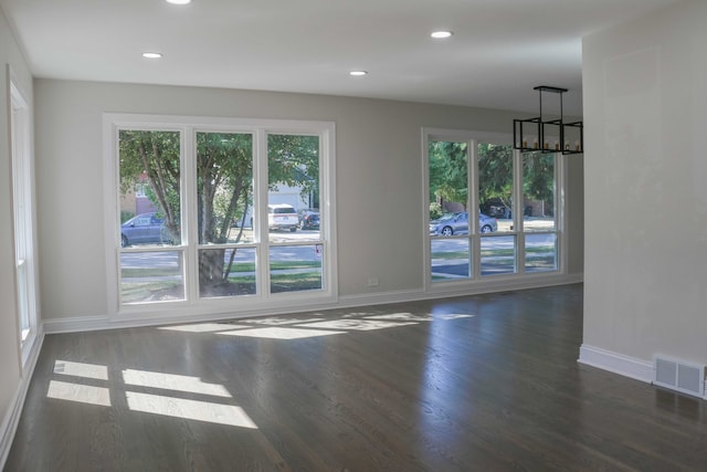 unfurnished room featuring visible vents, wood finished floors, recessed lighting, an inviting chandelier, and baseboards