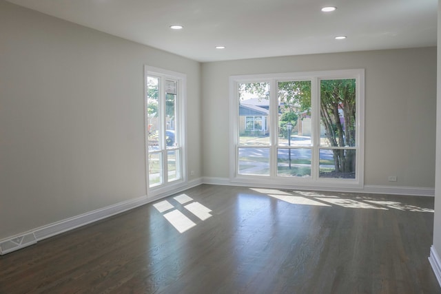 spare room featuring recessed lighting, visible vents, baseboards, and dark wood-style floors