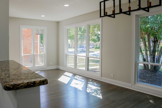 entryway with a wealth of natural light, baseboards, and dark wood-style floors