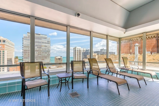 sunroom / solarium featuring vaulted ceiling and a water view