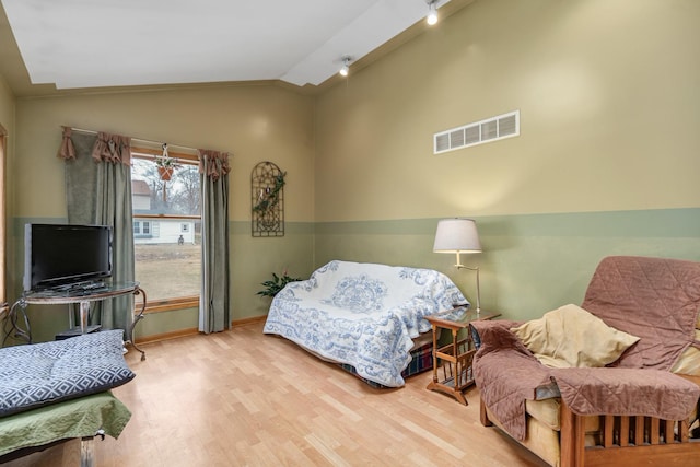 bedroom with hardwood / wood-style flooring and lofted ceiling