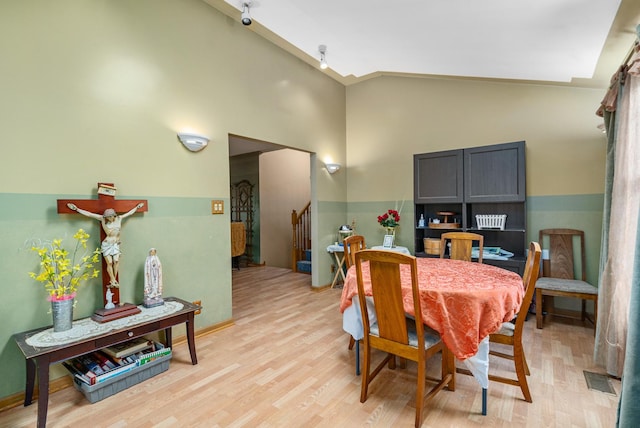 dining room with vaulted ceiling and light hardwood / wood-style flooring