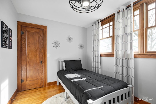 bedroom with light wood-type flooring and baseboards