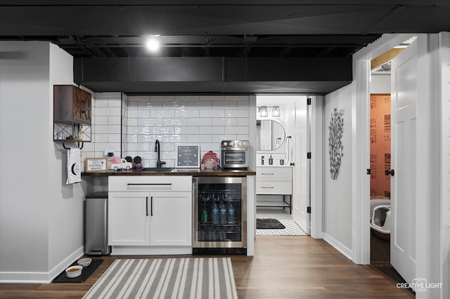 bar with tasteful backsplash, wine cooler, dark wood-style flooring, and a sink