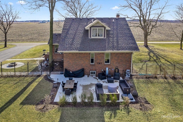 exterior space with a lawn, a chimney, fence private yard, a patio area, and brick siding