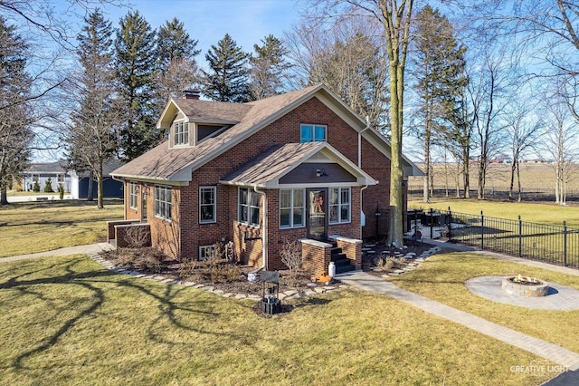 view of front of property with fence, an outdoor fire pit, a front yard, brick siding, and a chimney